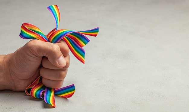 Homophobie. Stoppen Sie den LGBT-Stolz. Mann drückt Regenbogen-LGBT-Bänder in seiner Hand.