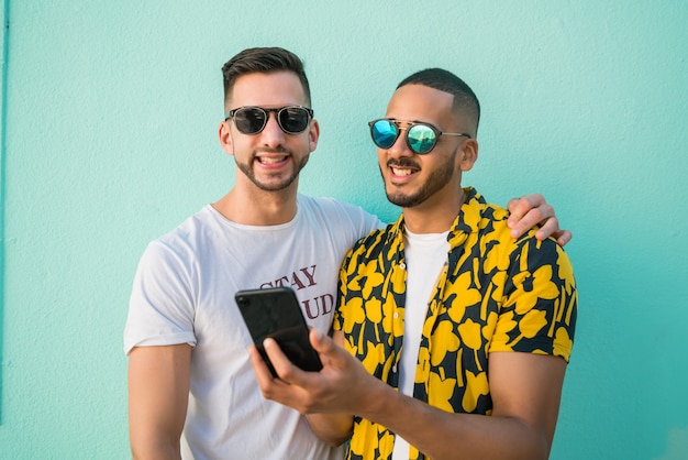 Homosexuelle Paare, die zusammen Zeit bei der Anwendung des Telefons verbringen.