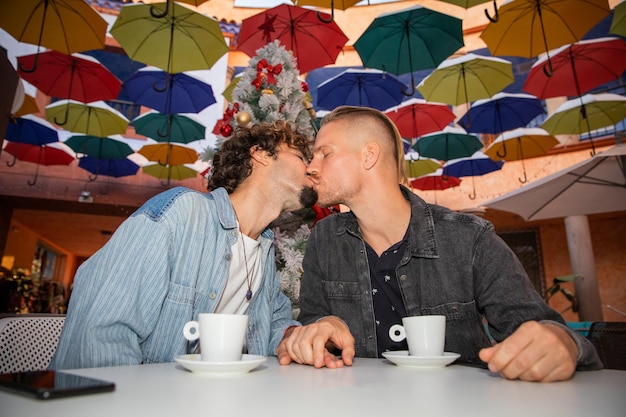 Homosexuelles Paar trinkt in den Weihnachtsferien Kaffee in einem Café