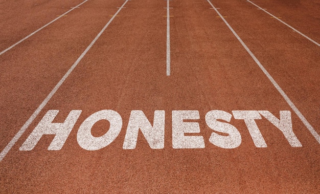 Honestidad escrita en la pista de atletismo Nuevo concepto en el texto de la pista de atletismo en color blanco