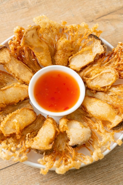 Foto hongo enoki frito y hongo ostra rey con salsa picante - estilo de comida vegana