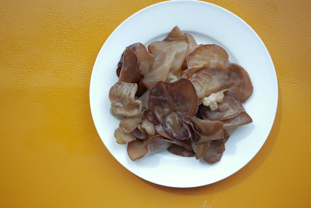 Hongo negro en un plato sobre fondo naranja