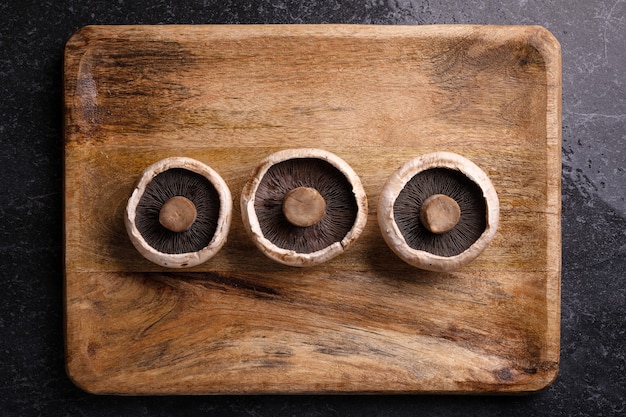 Hongos portobello enteros sobre bandeja de madera