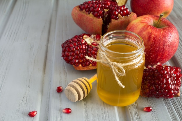 Honig, Granat und Äpfel auf dem grauen Holz