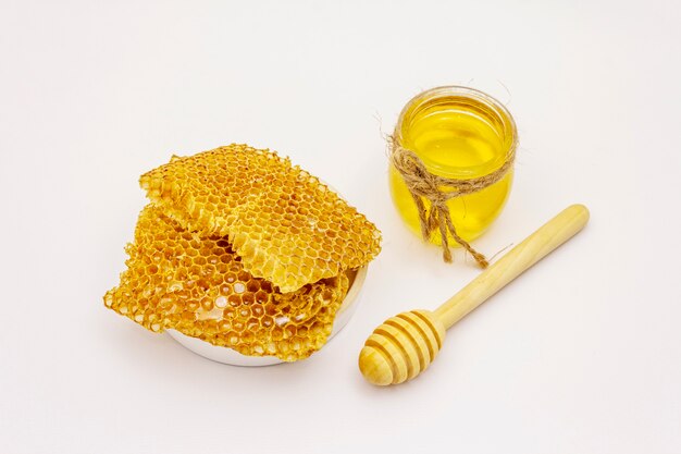 Honig, hölzerner Honigschöpflöffel und Waben lokalisiert auf weißem Hintergrund