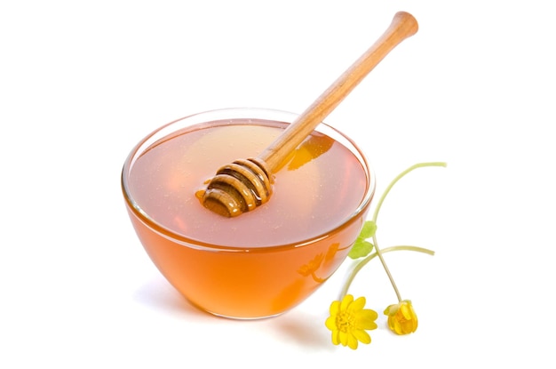 Honig in der Glasschüssel mit Dipper isoliert auf weißem Hintergrund