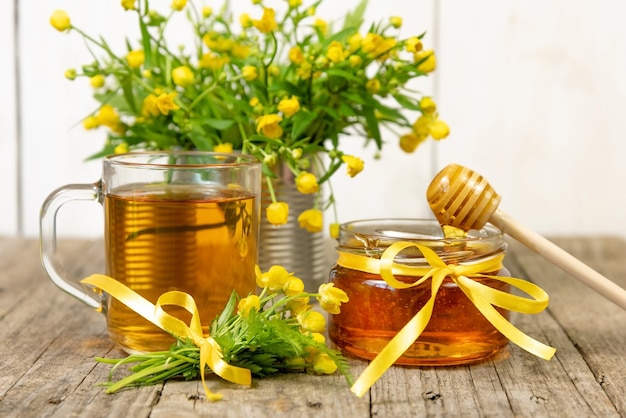 Honig in einem Glas mit gelben Blüten.