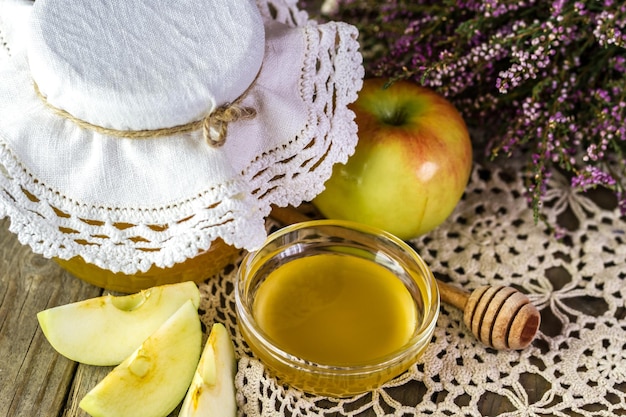 Honig in einer Schüssel mit einem Apfel auf dem Tisch