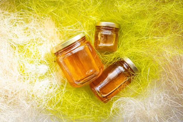 Honig in Glasgefäßen mit Blumenhintergrund