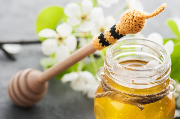 Honig mit Blüten und Holzlöffel