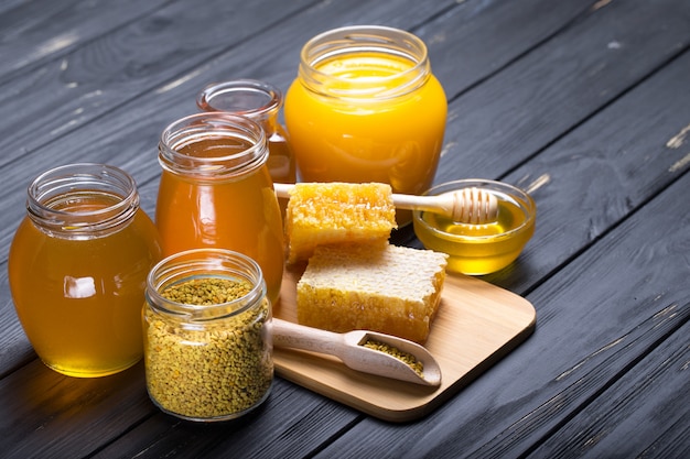 Honig mit hölzernem Honigschöpflöffel auf Holztisch