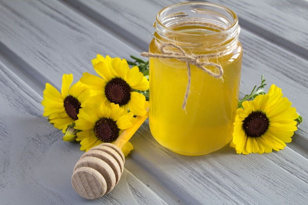 Honig und Blumen auf dem grauen Holz