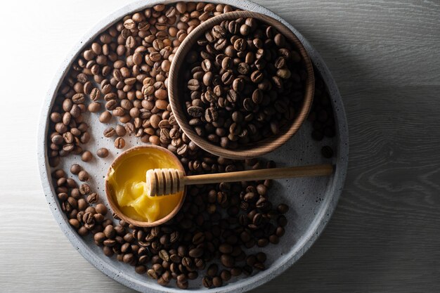 Honig und Kaffeebohnen auf Holzhintergrund, abstrakt.