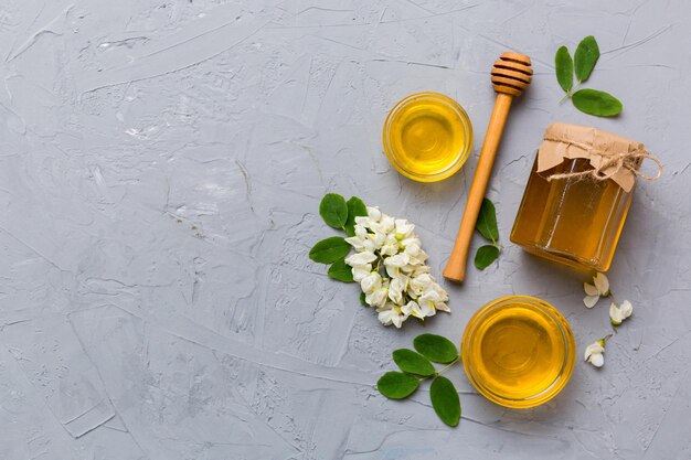 Honigglas mit Akazienblüten und Blättern frischer Honig Draufsicht flach gelegt