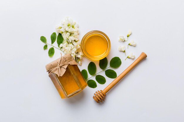Honigglas mit Akazienblüten und Blättern frischer Honig Draufsicht flach gelegt