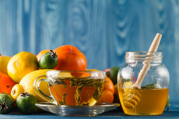 Honigglas und frische Äpfel mit Granatapfel über grünem Bokeh-Hintergrund