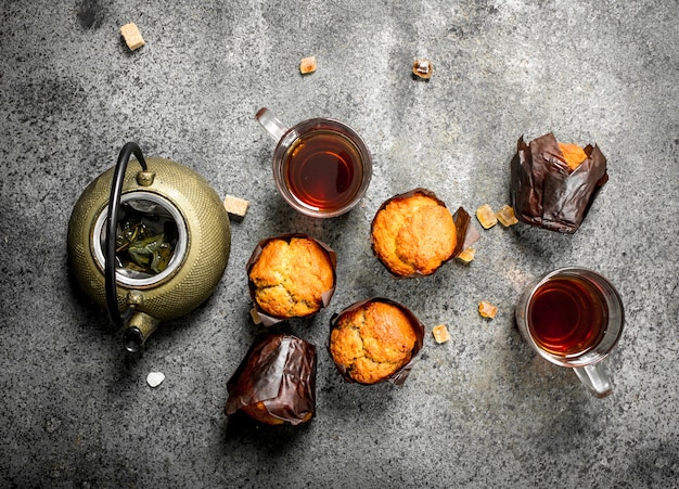 Honigmuffins mit einer Teekanne auf einem rustikalen Hintergrund