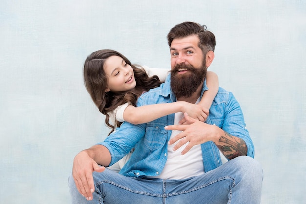 Honrando os pais e celebrando a paternidade filha abraçando o pai no dia dos pais homem barbudo e criança pequena comemorando o dia internacional dos pais juntos feliz dia dos pais