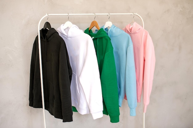 Hoodies de cores diferentes penduram em um cabide