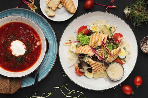 Hora del almuerzo, sopa y ensalada en la mesa del restaurante, vista superior