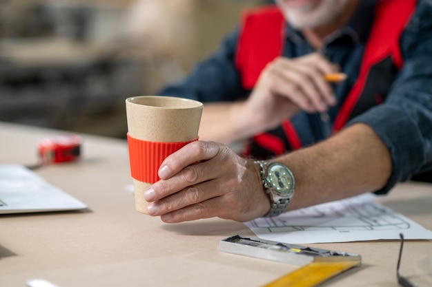 Hora de cafe. Cerrar imagen de mans mano con un vaso de papel