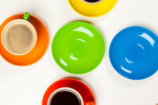 Hora del café con coloridas tazas y platos de café.