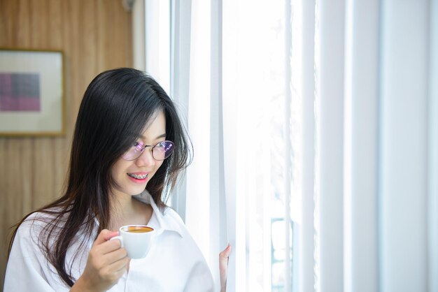 La hora del café de la mujer de la oficina usa anteojos en la oficina