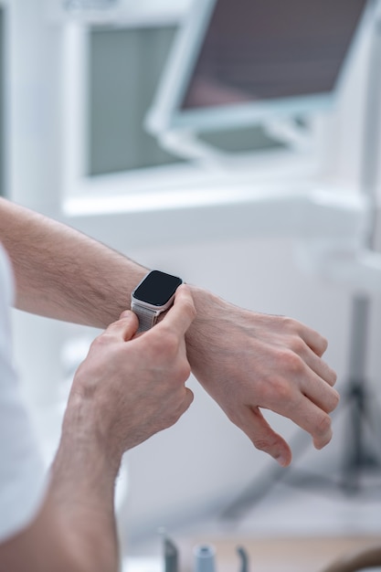 Hora. Cerrar imagen de un brazo masculino con un reloj inteligente