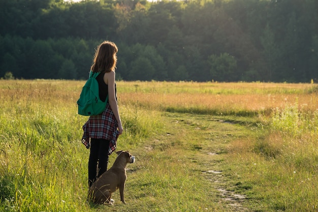 Hora da aventura para uma jovem fêmea e seu cachorro staffordshire terrier