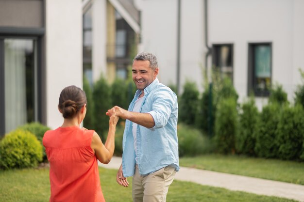 Hora de dançar. marido bonito de cabelos grisalhos dançando com sua adorável esposa de cabelos escuros