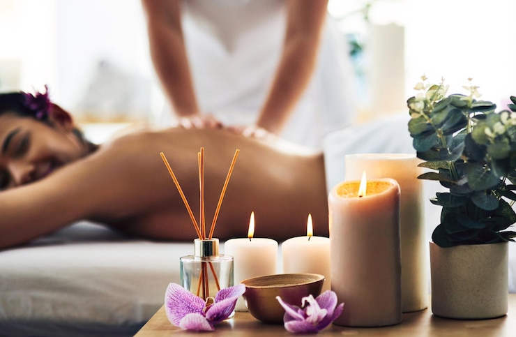 Foto hora de desacelerar as coisas tiro de fundamentos de spa em uma mesa com uma mulher recebendo uma massagem ao fundo