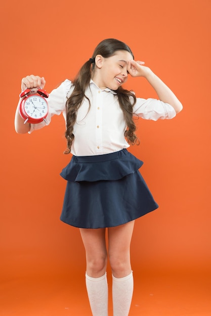 Hora de estudar As aulas começam Desenvolvendo a disciplina Tempo para pausa e descanso Tempo de férias Horário do sino do dia da escola primária Conceito de horário escolar Evite se atrasar Estudante segura o despertador