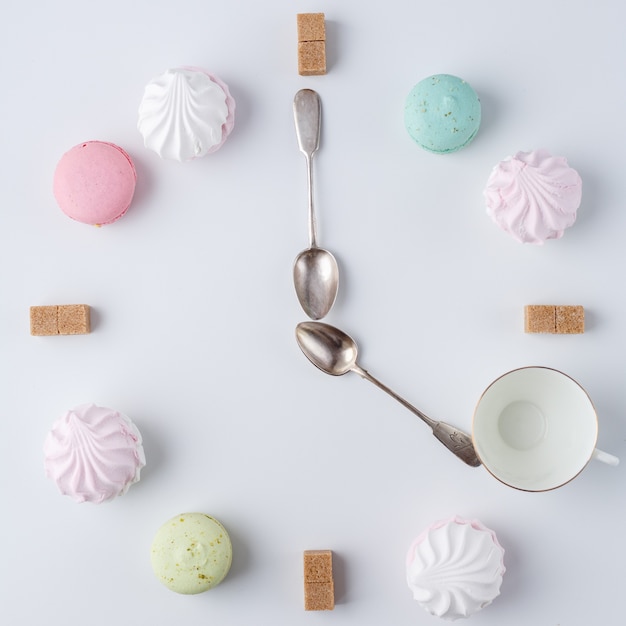 É hora de tomar um café. um relógio em forma de café. macarons, açúcar, marshmallows. trabalho criativo e criativo.