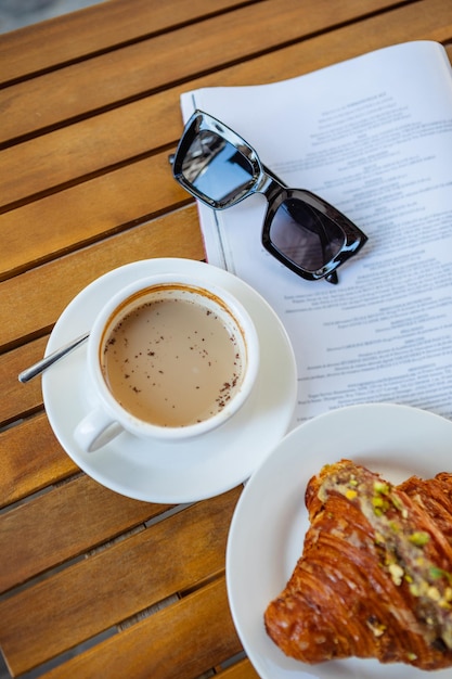 Hora del desayuno con café croissant y revista.