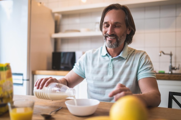 Hora del desayuno. Hombre soltero desayunando en la cocina de casa