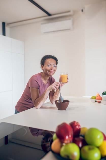 Hora del desayuno. Linda joven de piel oscura con un desayuno saludable