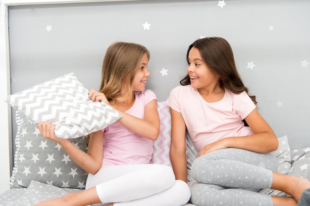 Hora de divertirse en la noche Ideas para fiestas de pijamas Niñas felices mejores amigas o hermanos en lindos y elegantes pijamas con almohadas fiesta de pijamas Hermanas divirtiéndose fiesta de pijamas Pelea de almohadas fiesta de pijamas