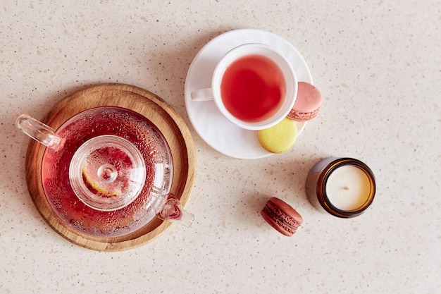 Hora do chá de outono com xícara de chá bule de vidro e macaroons Chá natural de frutas de framboesa de ervas