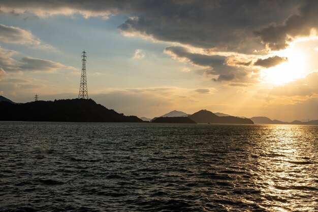 Hora do pôr-do-sol no Mar Interior de Seto, Japão Reflexão dourada na superfície do oceano