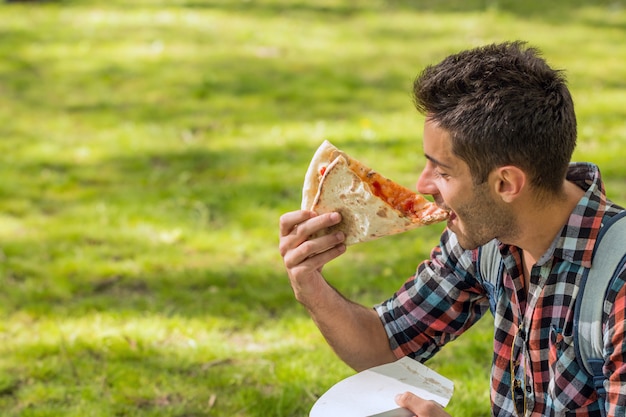 Hora de la pizza. Estudiante con almuerzo.