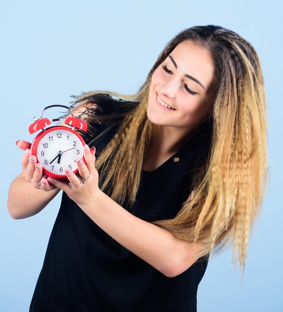 Horário de verão Alterar fuso horário Conserto de relógios Gerenciamento de tempo Pontualidade e disciplina Menina bonita gerenciando seu tempo Mulher segura despertador vintage Prática de relógios avançados