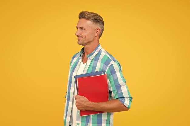 Foto horario diario, ¿estás listo para el examen? retrato de estudiante masculino. un hombre guapo disfruta de estudiar en casa. concepto de educación en casa. educación y conocimiento. el hombre trabaja como asistente de oficina