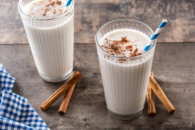 Horchata fresca con canela en vidrio sobre mesa de madera rústica