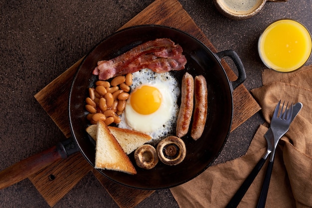 Horizontal del clásico pan frito delicioso desayuno inglés rústico graso en mesa de madera