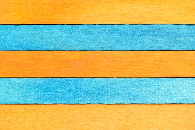 Horizontaler Hintergrund aus abwechselnd bemalten Holzplatten in orangefarbenen und blauen Farben aus Holz