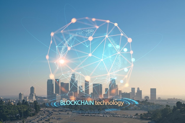 Horizonte del centro de Los Ángeles al atardecer de verano California EE. UU. Rascacielos del centro panorámico de la ciudad de LA Economía descentralizada Holograma de concepto de blockchain y criptografía