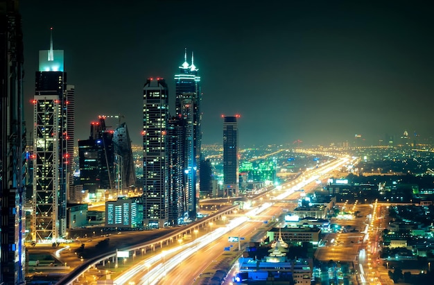 El horizonte del centro de Dubai nocturno con los rascacielos más altos y la carretera que conduce a Abu Dhabi durante la hora punta Dubai, Emiratos Árabes Unidos