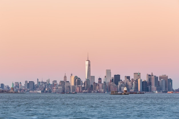 Horizonte del centro de Manhattan de Nueva York al anochecer con rascacielos iluminados sobre el panorama del río Hudson. Composición vertical, espacio de copia.