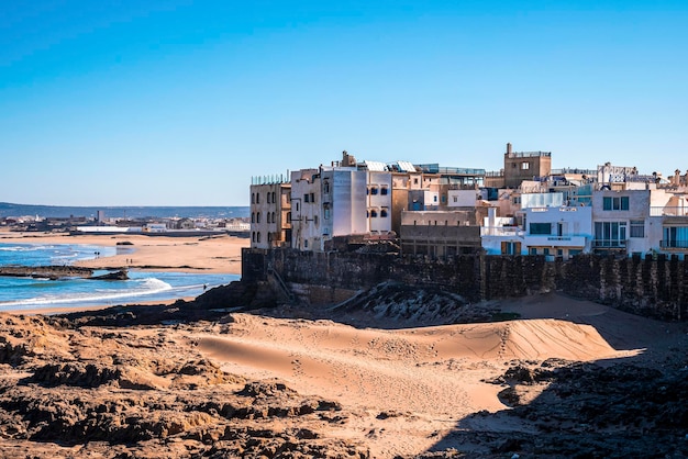 Horizonte de la ciudad con formaciones rocosas en la playa en un día soleado contra el cielo azul