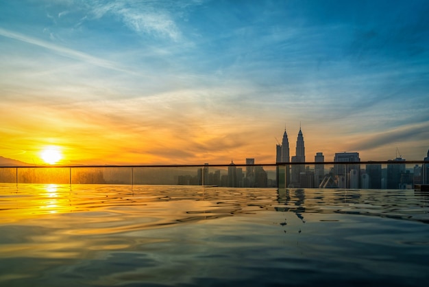 Horizonte de la ciudad de Kuala Lumpur con la piscina en el tejado del hotel al amanecer en Malasia.